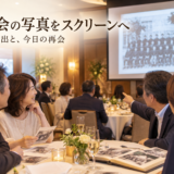 同窓会で昔の学校写真をスクリーンに映して楽しむイメージ