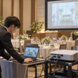 披露宴開始前にPCと投影機材を確認するイメージ