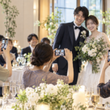 結婚式でゲストが新郎新婦の写真をスマートフォンで撮影する様子