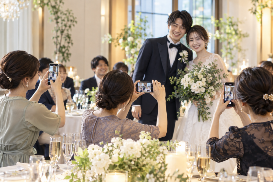結婚式でゲストが新郎新婦の写真をスマートフォンで撮影する様子